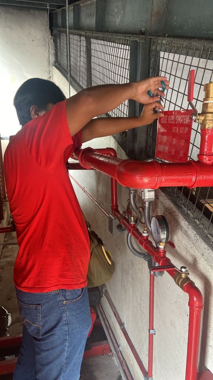 Technician working on hose reel pump pipework