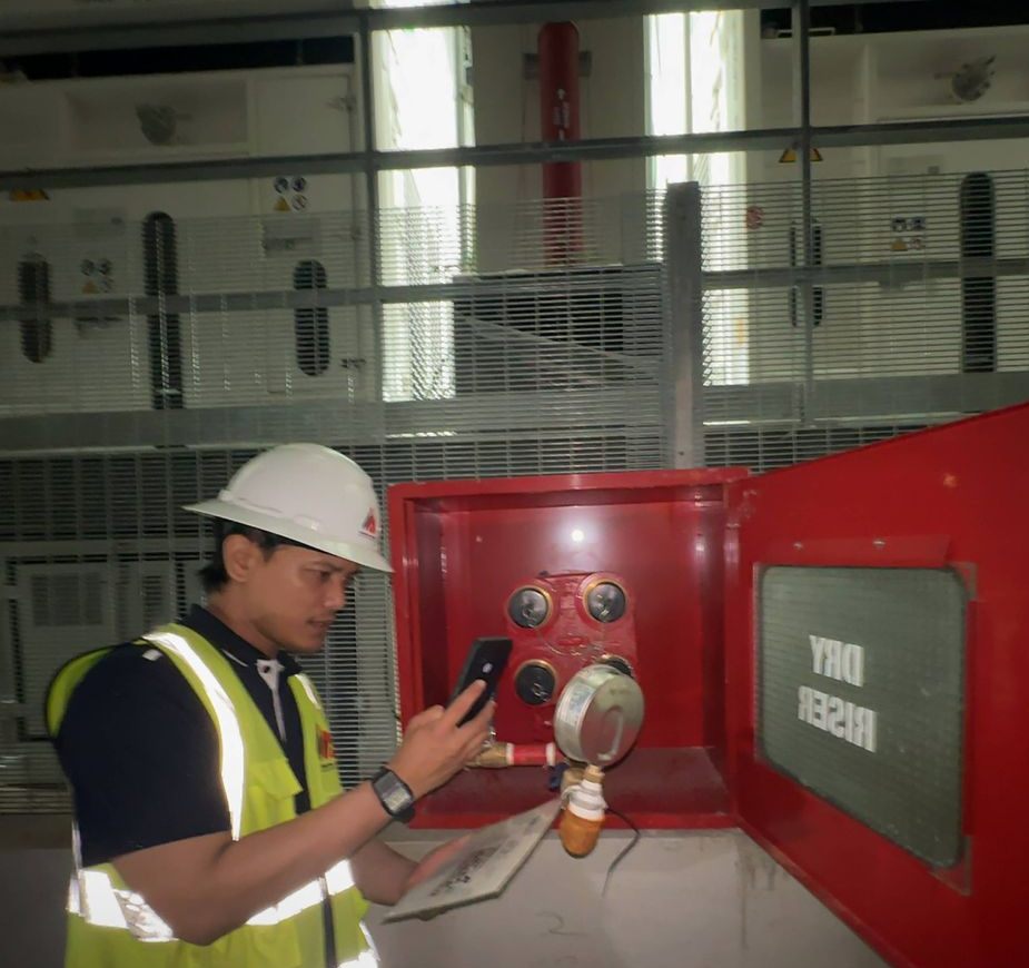 Technician inspecting a dry riser inlet box