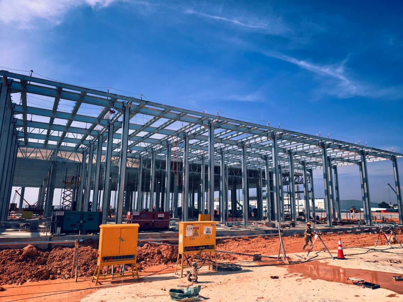 Steel-frame building under construction against a blue sky