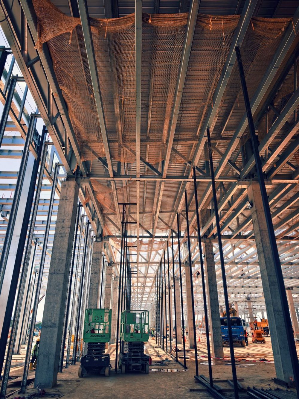 Scissor lifts inside a steel-frame building under construction